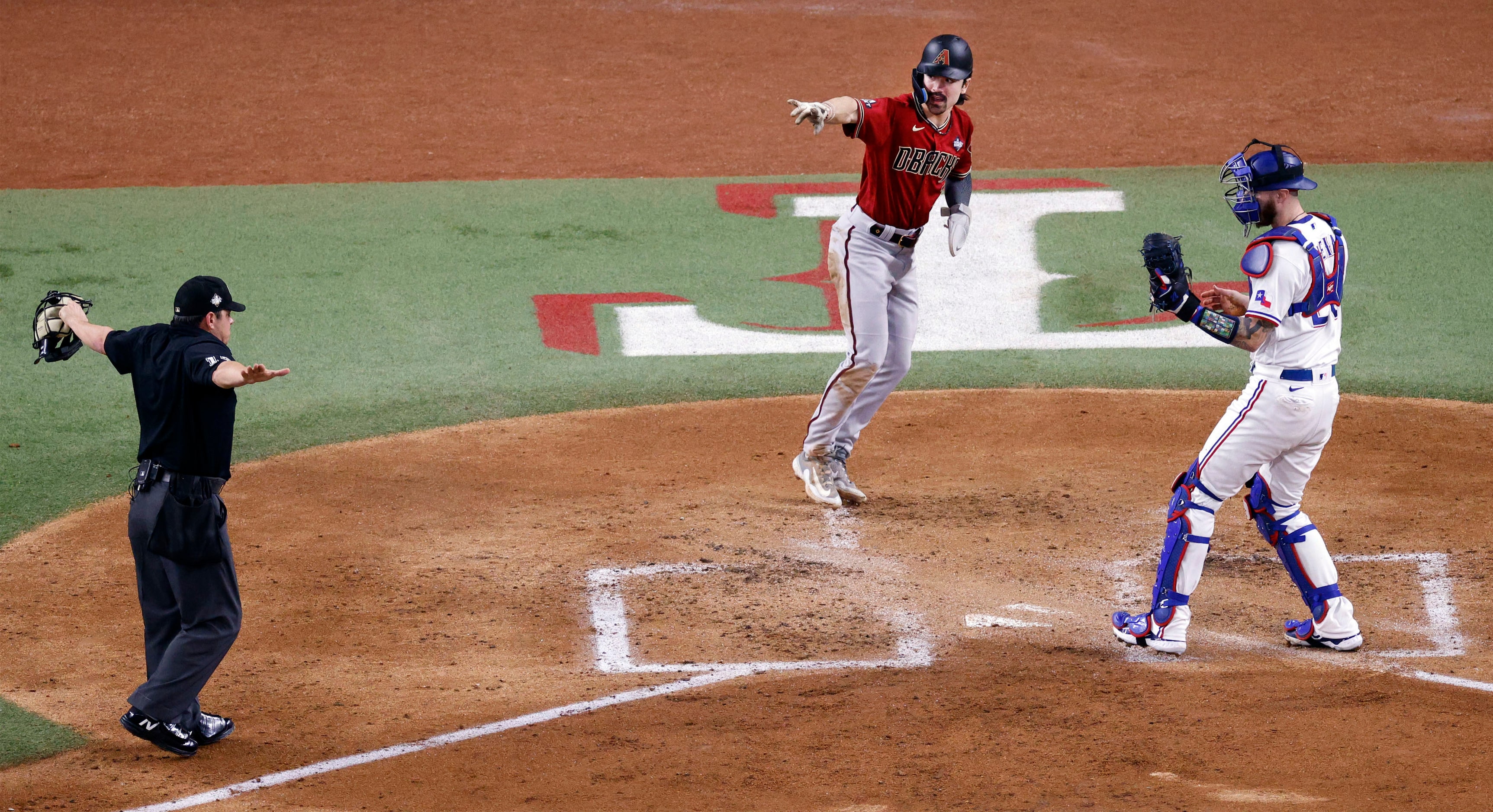 Arizona Diamondbacks left fielder Corbin Carroll (7), center, gestures after he slided...