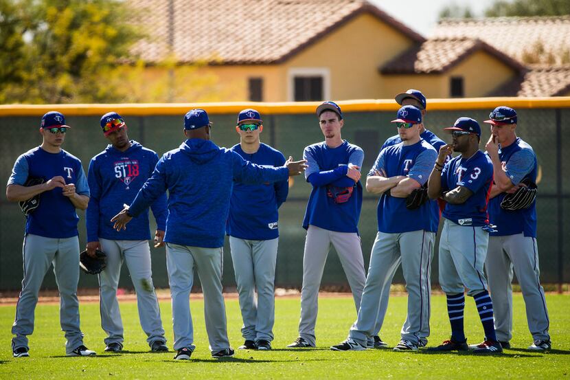 Texas Rangers outfielders gather between drills during the first full-squad spring training...