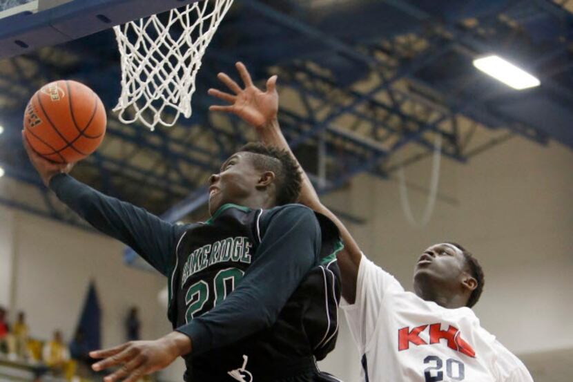 Mansfield Lake Ridge sophomore guard Mike Adewunmi, left, attempts a layup as Kimball Xaiver...