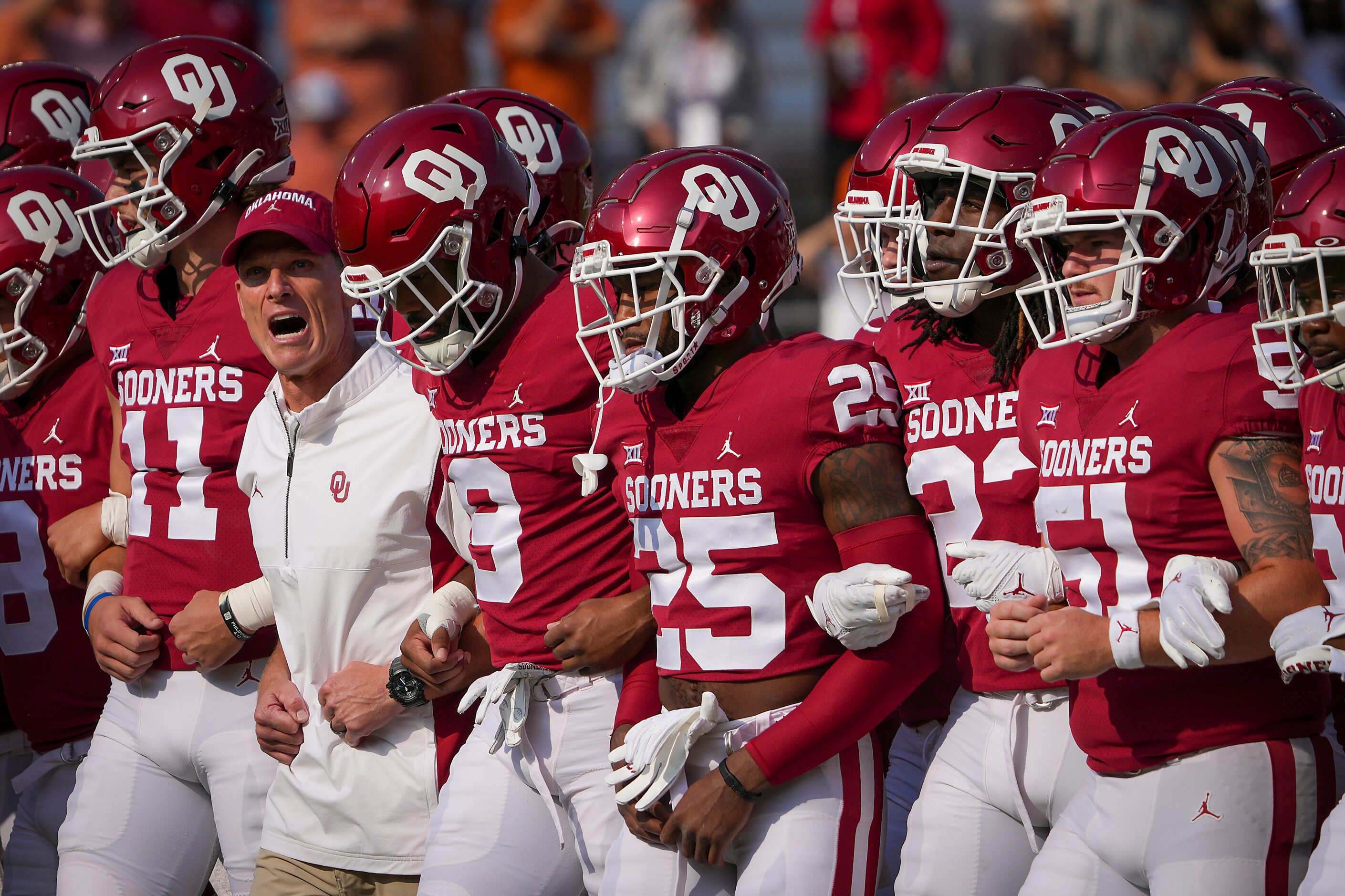 Oklahoma head coach Brent Venables walks the field arms locked with his players before the...