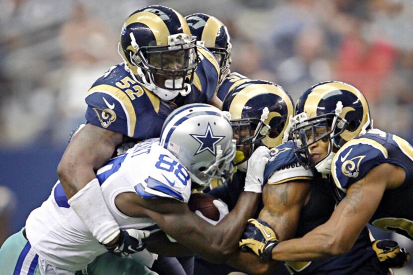 St. Louis Rams outside linebacker Alec Ogletree (52) and other defenders try to bring down...