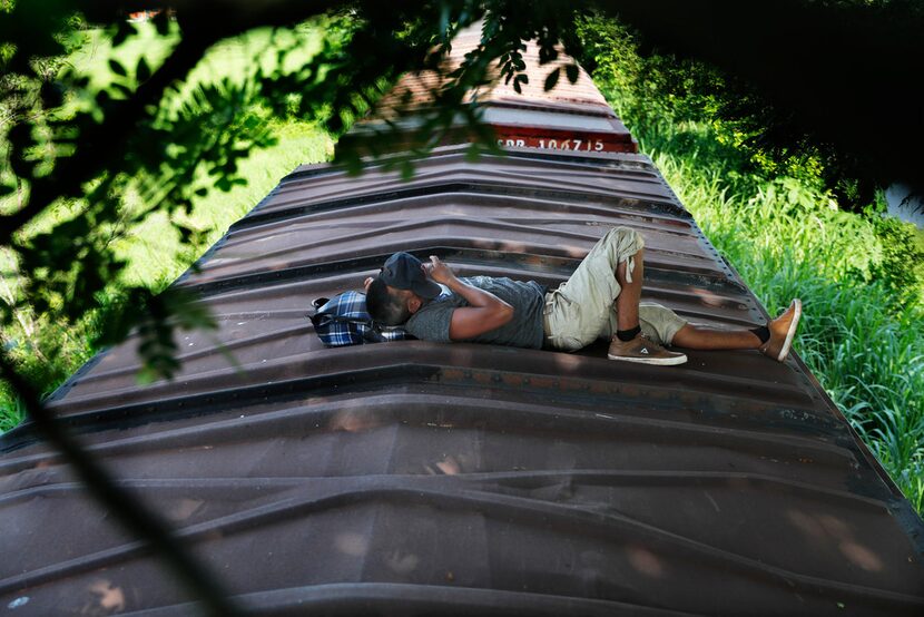 A Honduran migrant rides a freight train on his way north, in Salto del Agua, Mexico,...