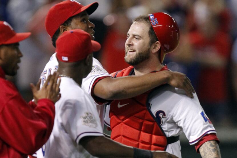 Rangers reliever Neftali Feliz (center) wraps up catcher Mike Napoli after closing down the...