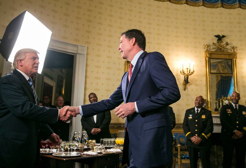 President Donald Trump shook hands with James Comey, the FBI director, at the White House on...