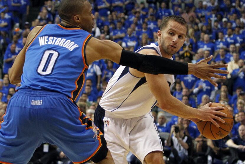 Dallas' JJ Barea passes around OKC's Russell Westbrook during the fourth period of play in...