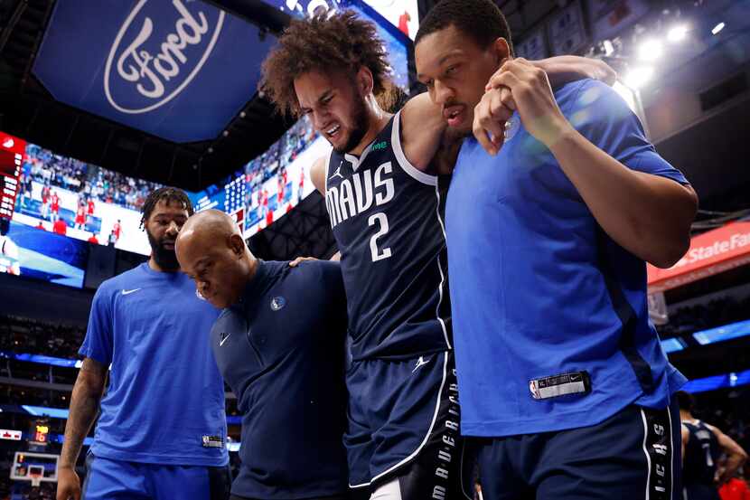 Dallas Mavericks center Dereck Lively II (2) is helped off the floor after sustaining a left...
