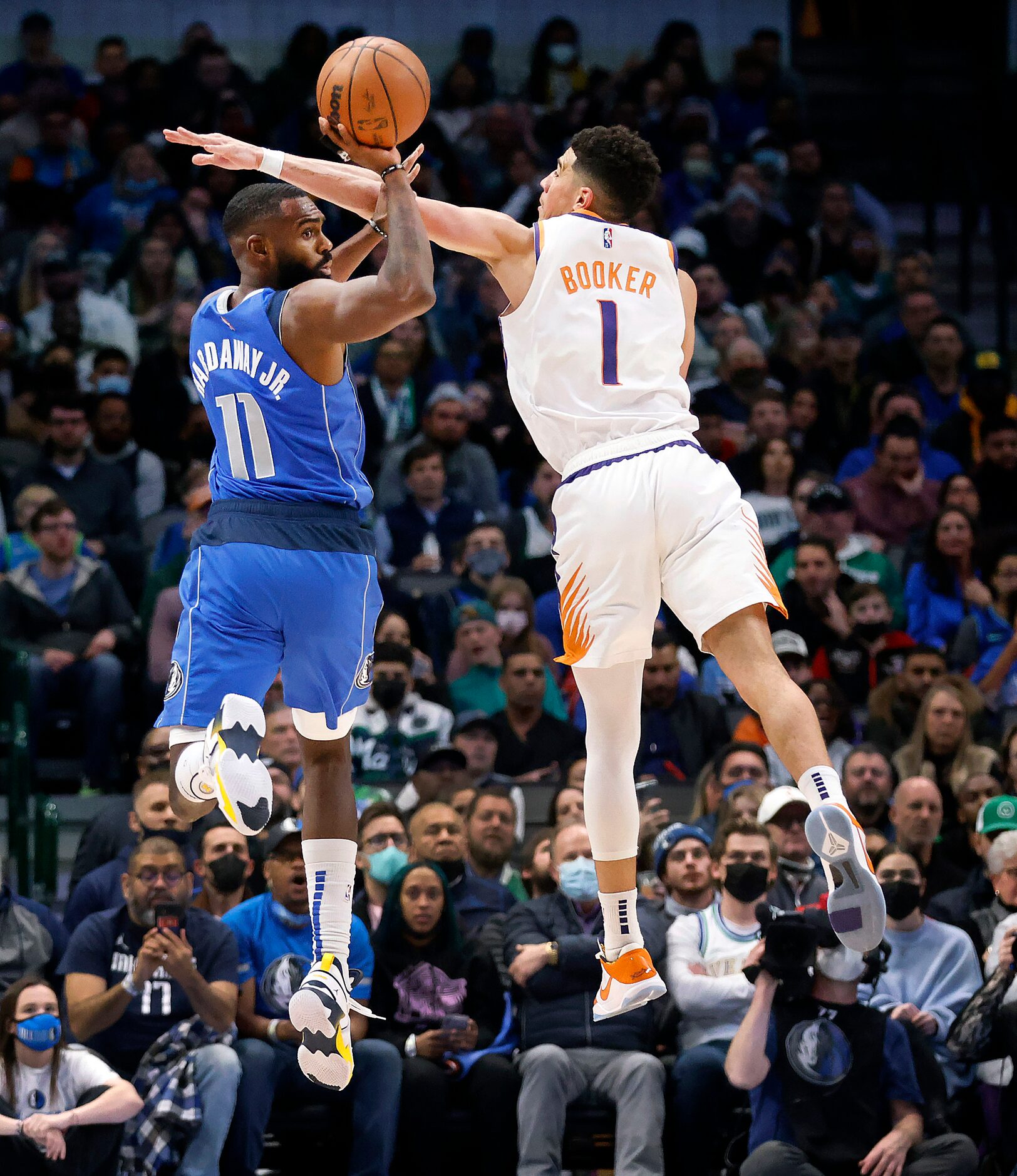 Dallas Mavericks forward Tim Hardaway Jr. (11) is turned away by Phoenix Suns guard Devin...