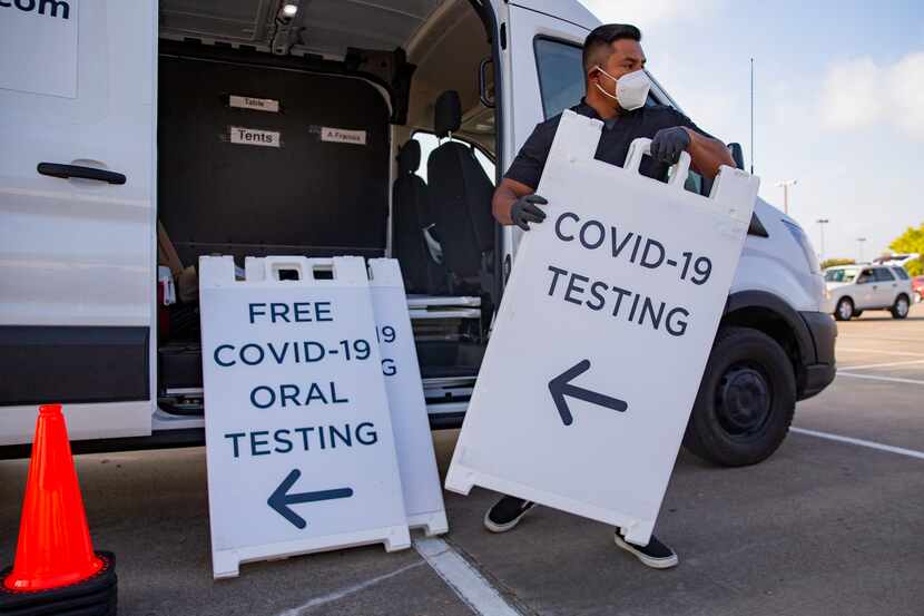 Juan Pérez, medical assistant at WellHealth, unloads signs advertising free COVID testing in...