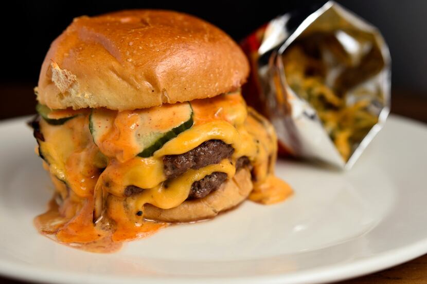 The Texas Akaushi smash burger is dressed with house-made American cheese, garlic mayo and...