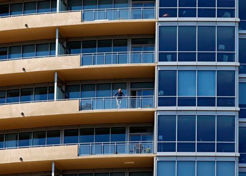 
A man watched the police activity below from a balcony.
