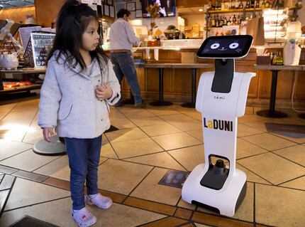 Sammi Patlan, 4, looks at robot Coqueta at La Duni in early 2022.