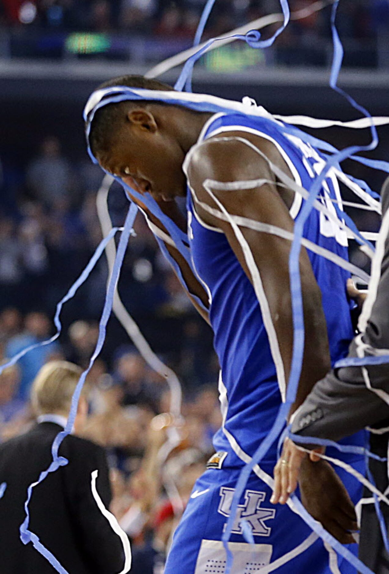 Strewn in confetti, Kentucky Wildcats forward Julius Randle (30) of Dallas walks off the...