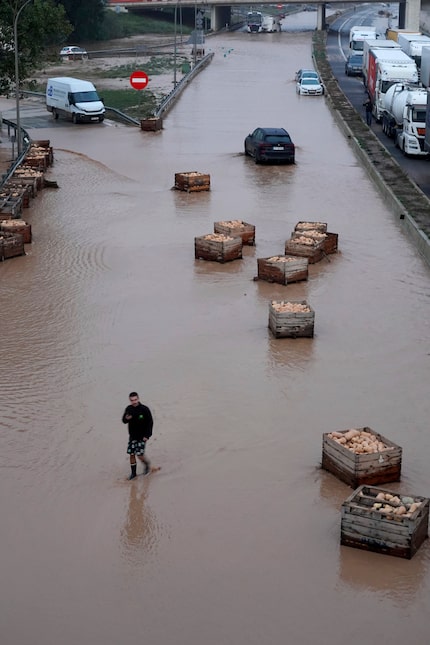 Un hombre camina por una carretera inundada en Valencia, el miércoles 30 de octubre de 2024....