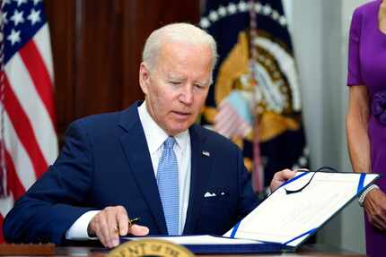 President Joe Biden signs the Bipartisan Safer Communities Act in the Roosevelt Room of the...