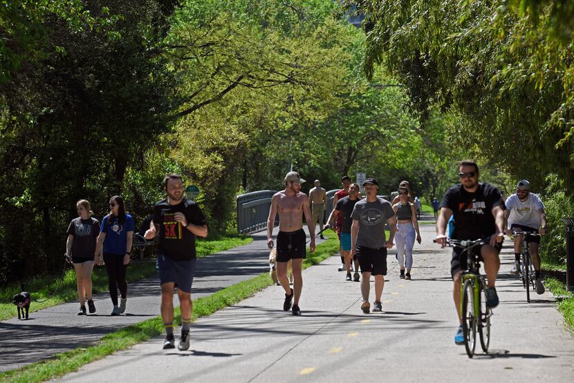 Groups of runners, cyclists and dog walkers use the Katy Trail near the Katy Trail Icehouse...