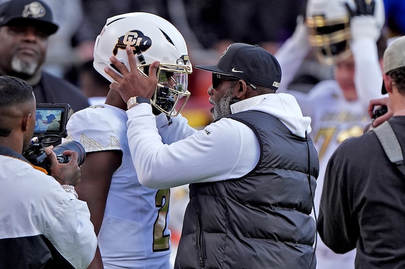 Colorado head coach Deion Sanders talks to quarterback Shedeur Sanders (2) before an NCAA...