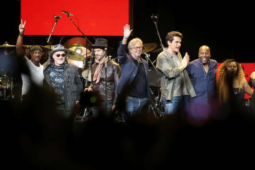 Eric Clapton (center) and friends acknowledge the crowd's applause after a finale, during...