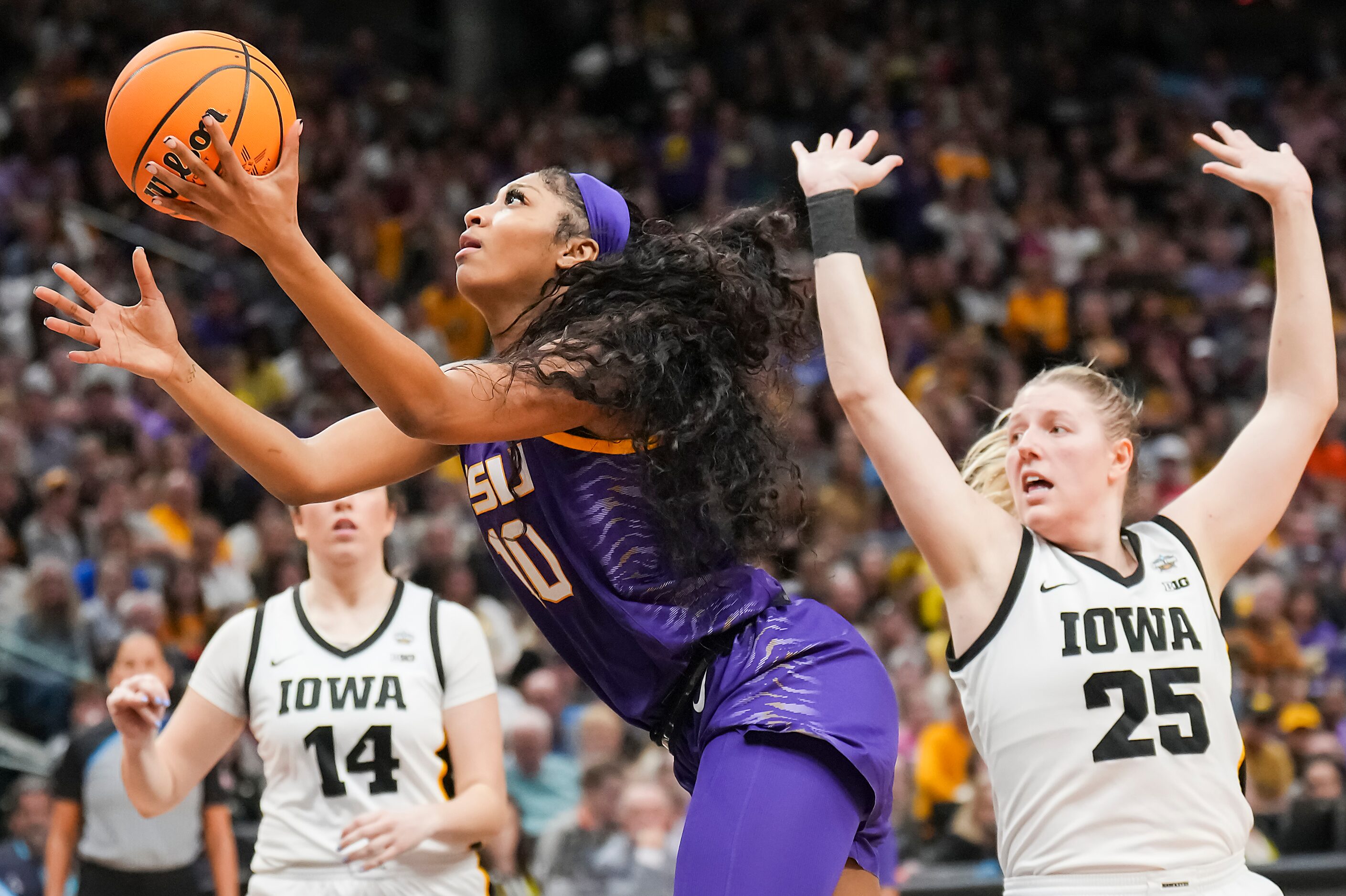 LSU forward Angel Reese (10) scores past Iowa forward Monika Czinano (25) during the second...