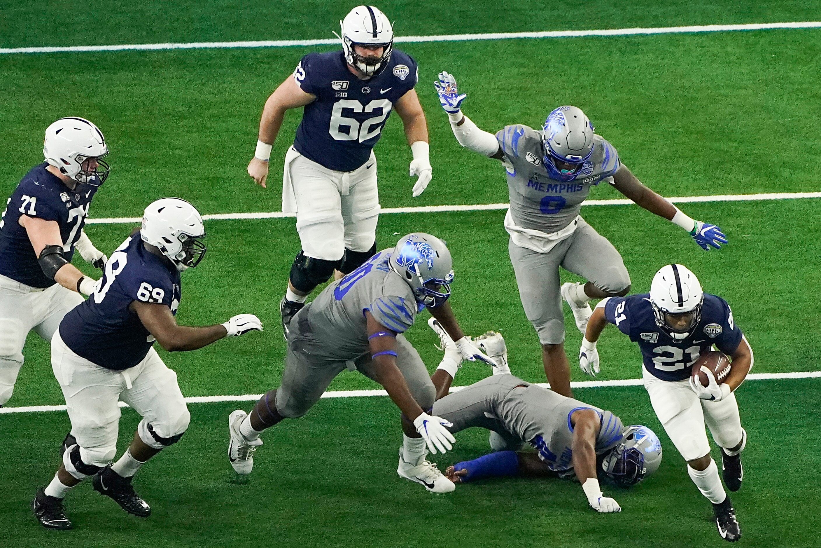 Penn State running back Noah Cain (21) breaks through the Memphis defense during the first...