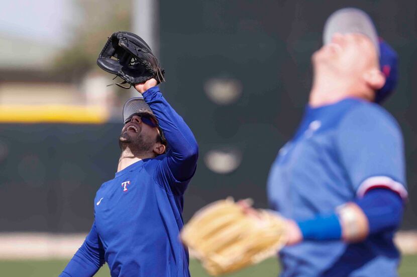 Texas Rangers infielders Josh Smith, left, and Josh Jung, look to catch a ball during a...