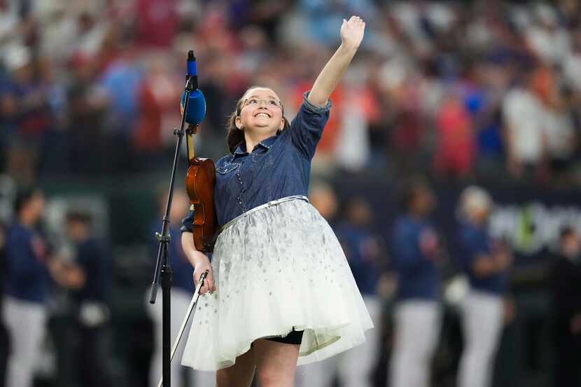 11-year-old violinist Sabrina Patel waves to the crowd after performing the national anthem...