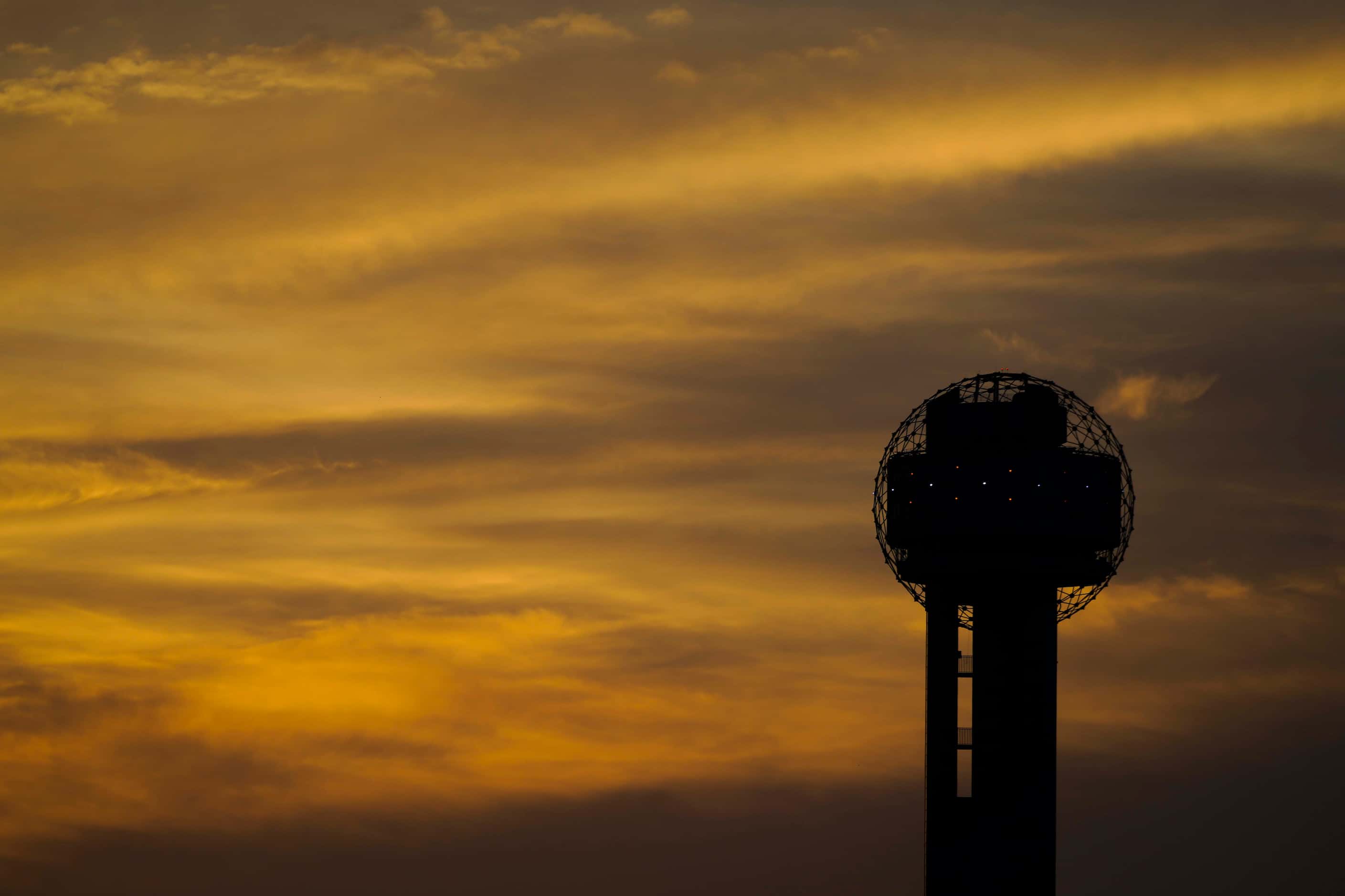 The sun sets behind Reunion Tower on Tuesday, June 30, 2020, in Dallas. Dissipating Saharan...