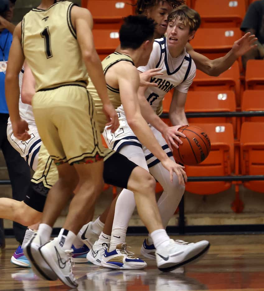 Keller guard Alex Peterson (0), right, is swarmed by Plano East defenders as he looks for a...