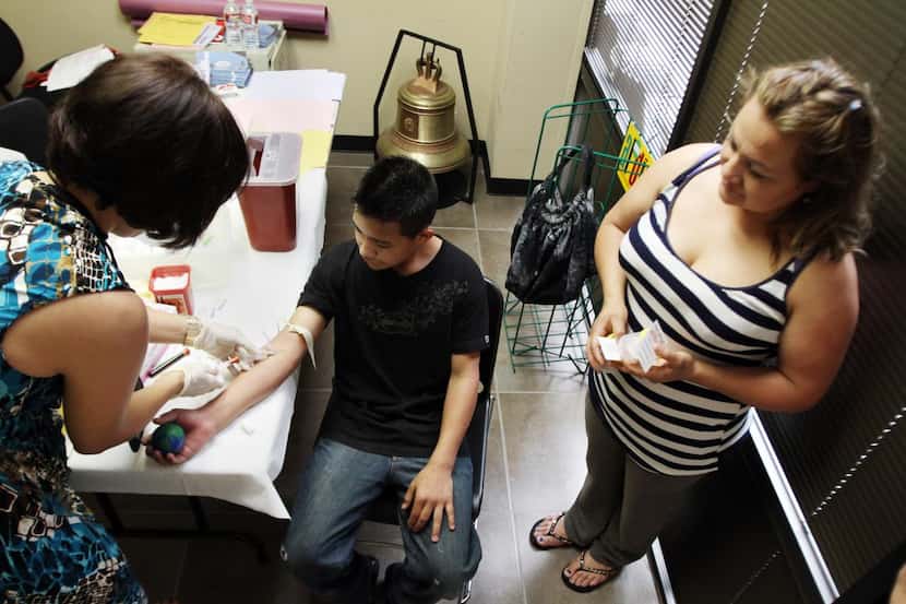 Una familia se hace la prueba del VIH en el Consulado de México durante una jornada...