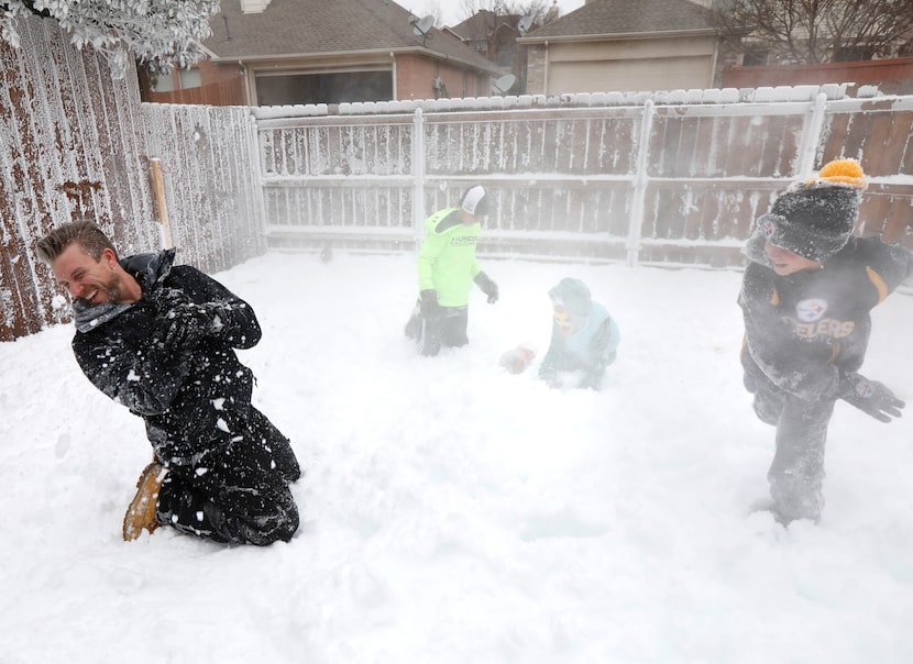 Jeramy Melchiorre, left, gets hit with a snowball thrown by his son, Christian Melchiorre,...