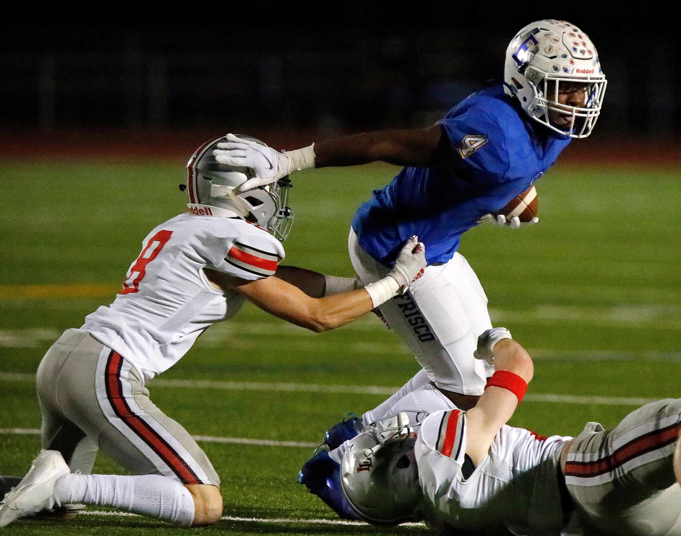 Frisco High School wide receiver Chase Lowery (4) stiff arms Lovejoy High School defensive...