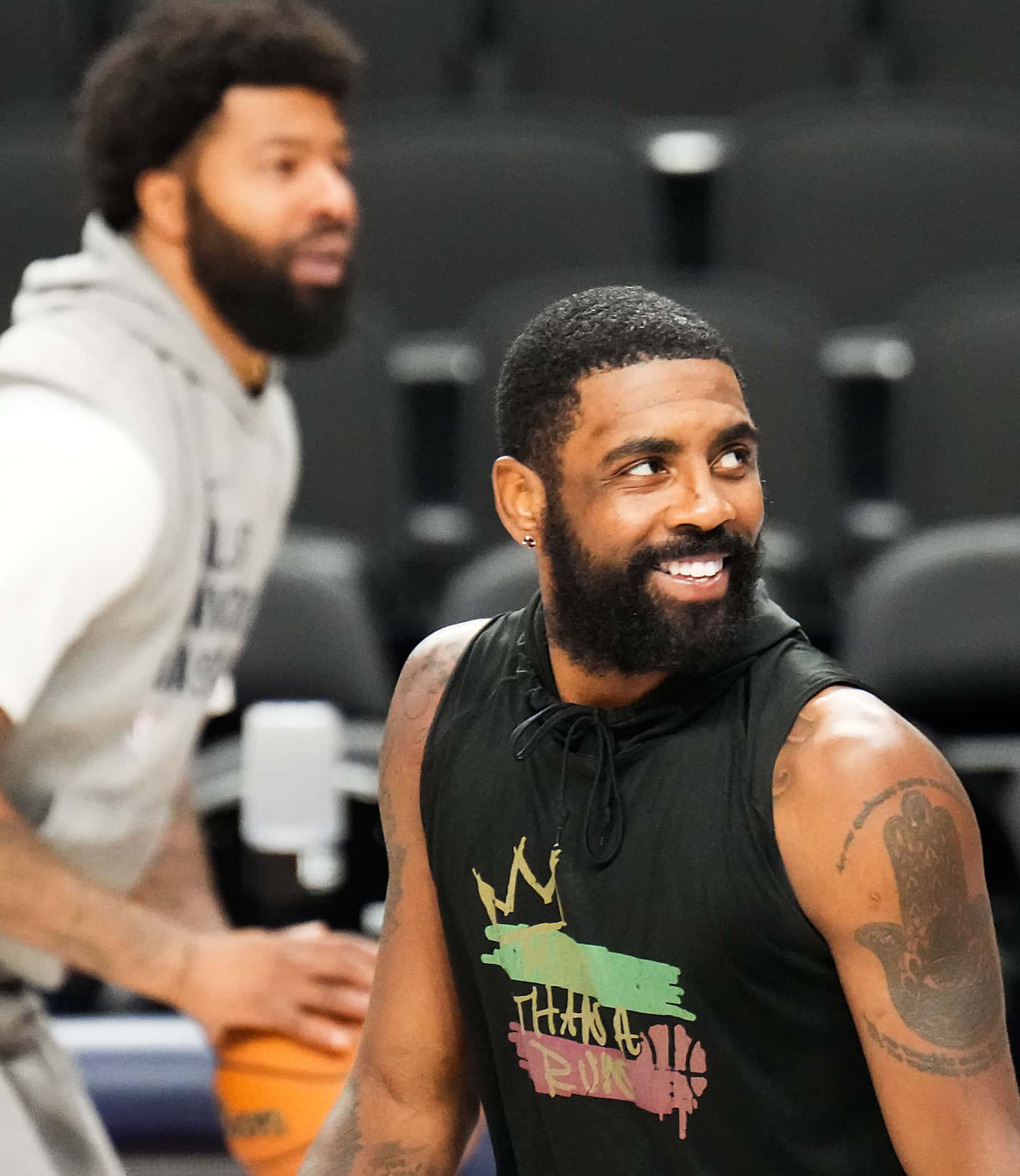 Dallas Mavericks guard Kyrie Irving laughs with teammates during practice in preparation for...