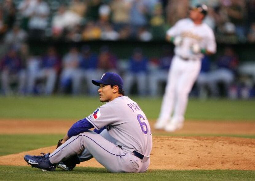  Chan Ho Park #61 of the Texas Rangers looks to second base after a throwing error that...