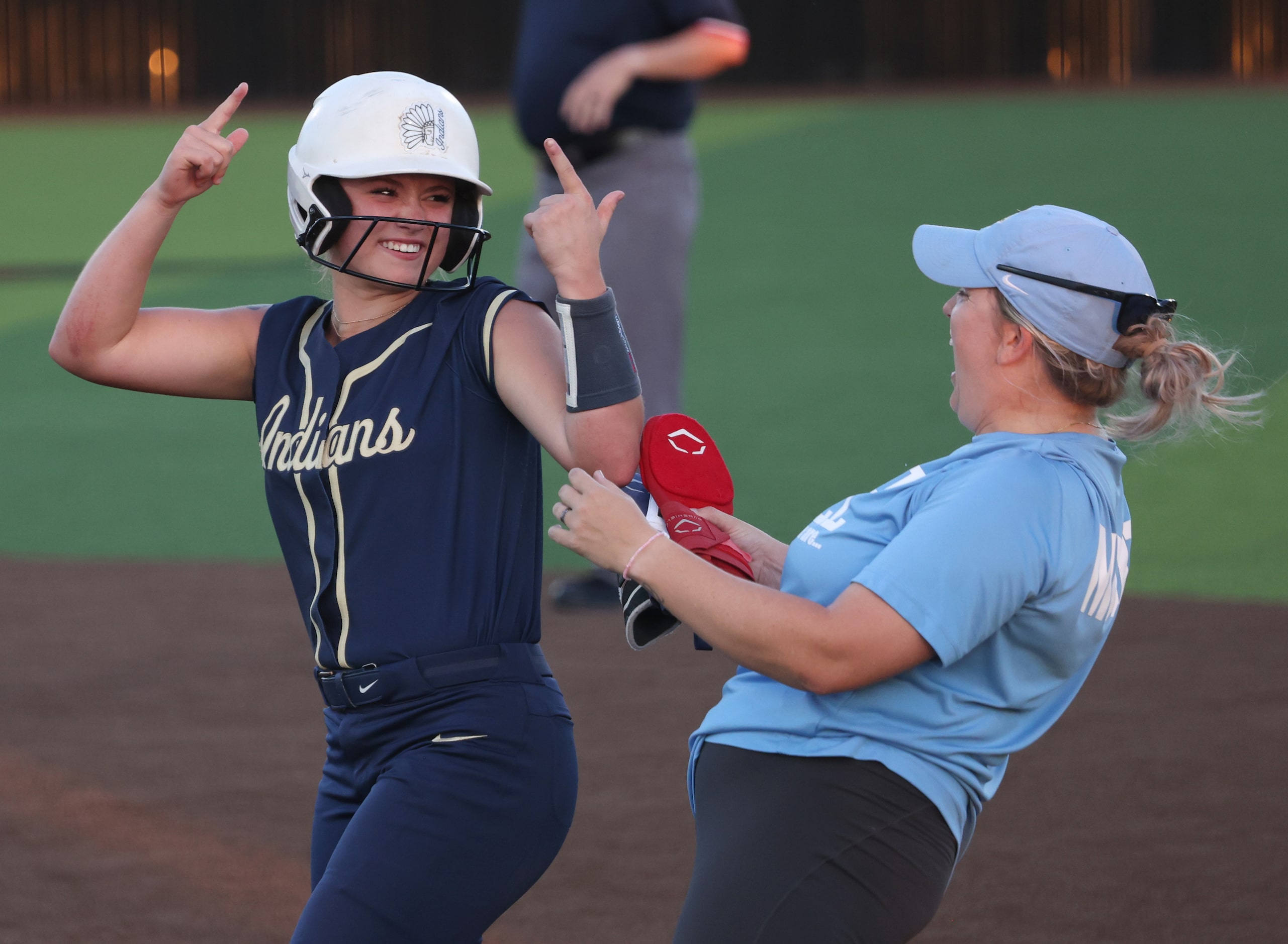 Keller's Mackenna Jackson (8), left, celebrates with an assistant coach at first base after...