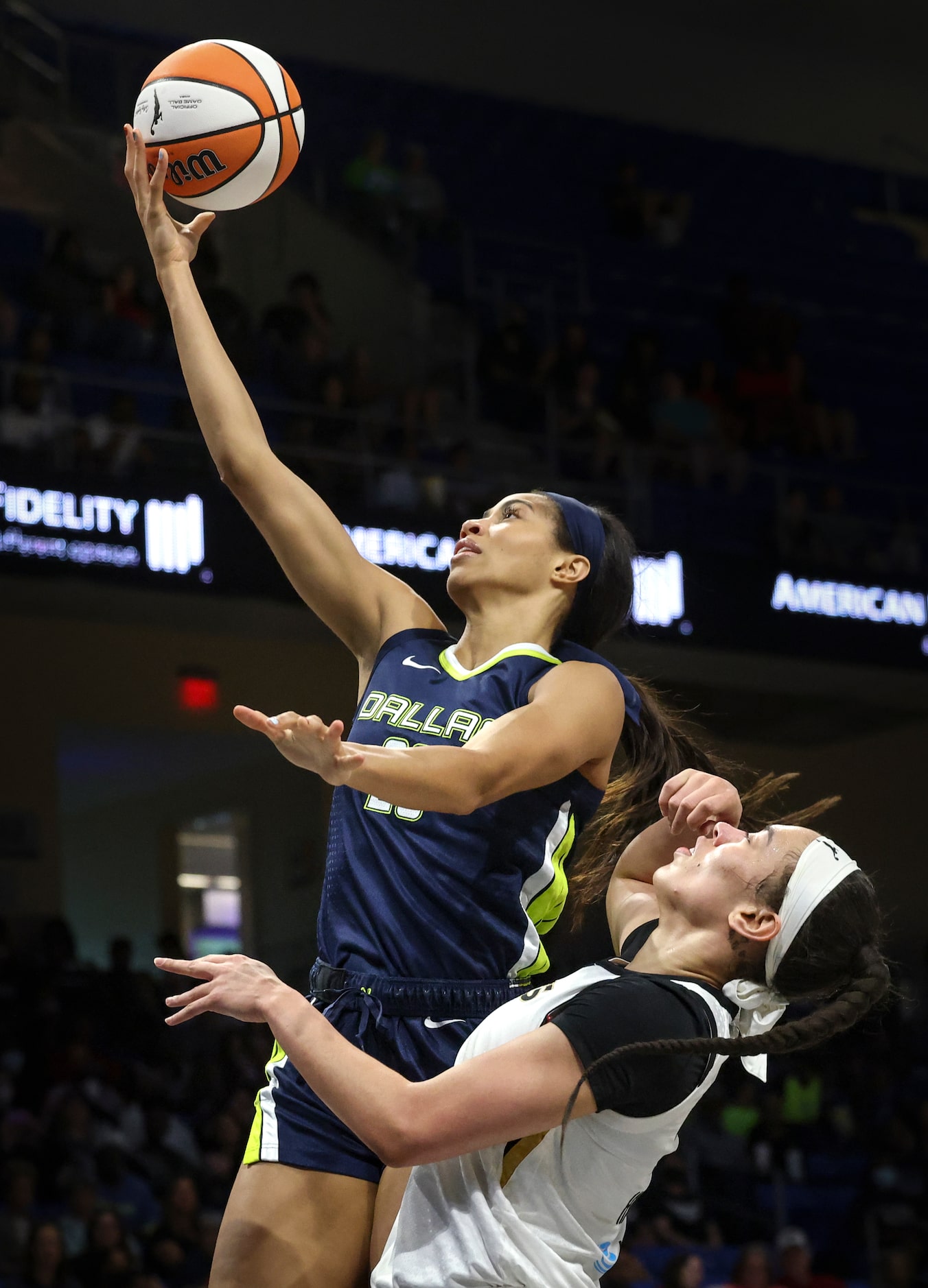 Dallas Wings forward Isabelle Harrison (20) does a layup, defended by Las Vegas Aces forward...