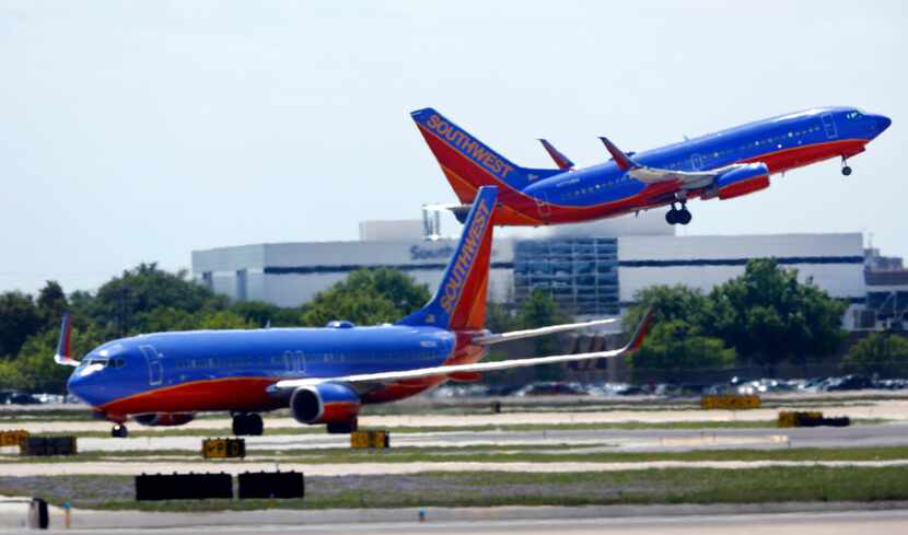 A Southwest Airlines jet takes off in front of company headquarters at Dallas Love Field in...