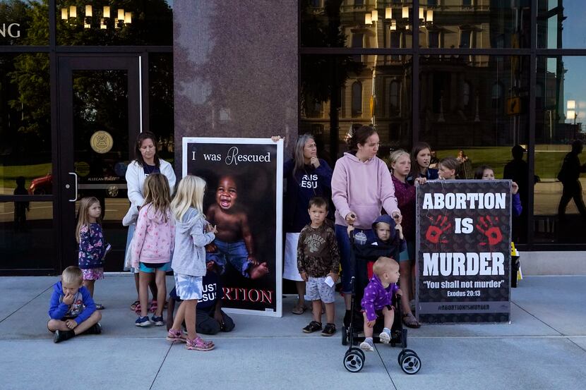 Abortion opponents are seen outside as the Michigan Board of State Canvassers meet during a...