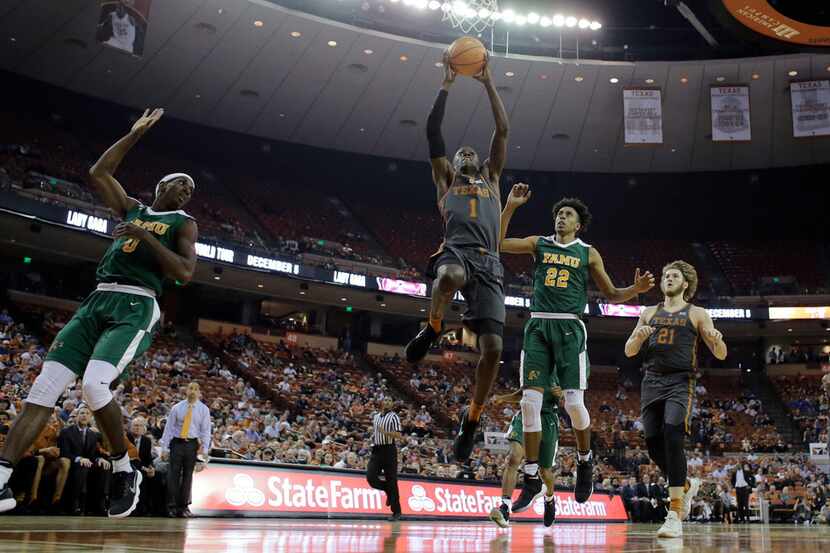 Texas guard Andrew Jones (1) drives to the basket past Florida A&M guard Marcus Barham (22)...