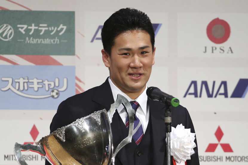 Japanese star pitcher Masahiro Tanaka of Rakuten Golden Eagles poses with his grand prix...