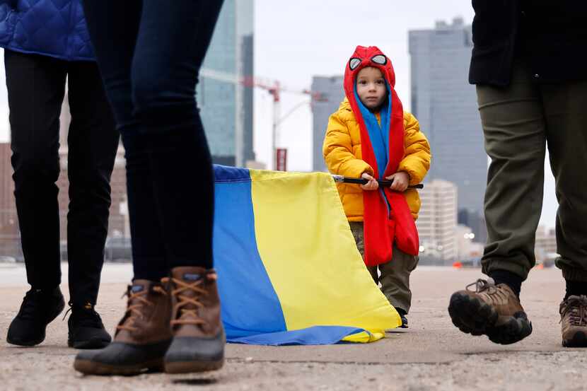 A young boy carries a Ukrainian national flag as a group of supporters gathered in downtown...