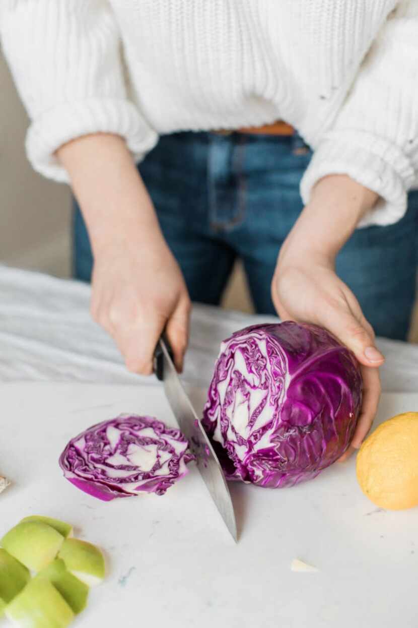 woman chopping purple cabbage in the kitchen