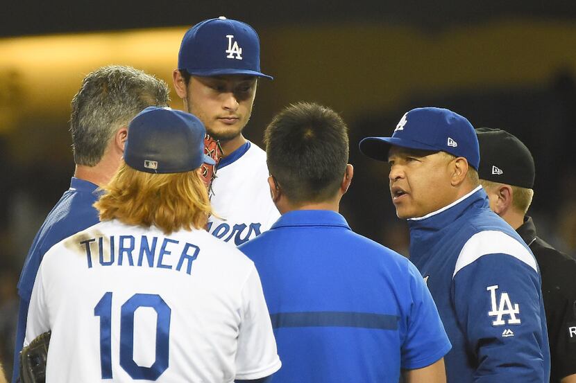 LOS ANGELES, CA - AUGUST 16:  Justin Turner #10 listens as manager Dave Roberts #30 of the...