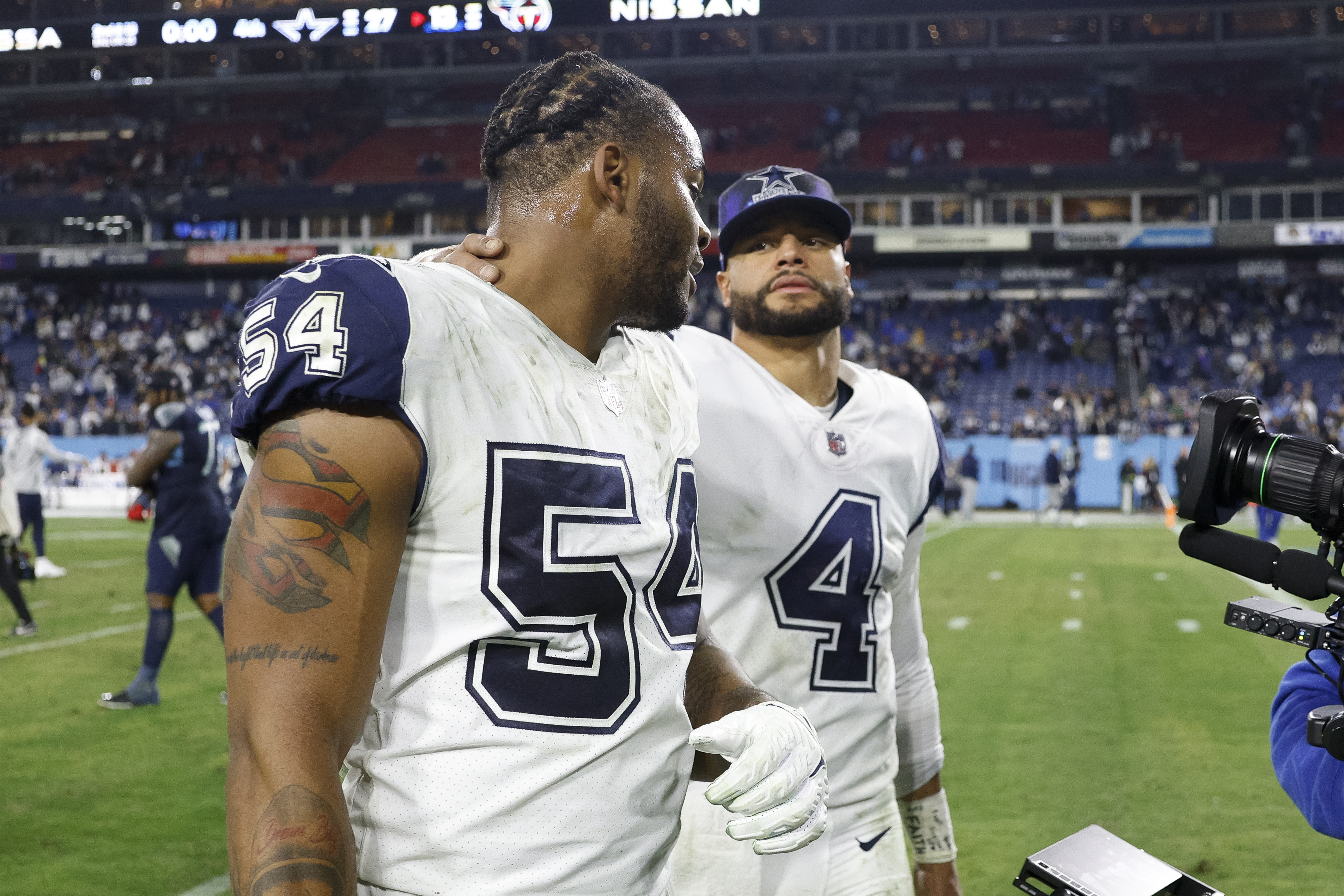 Dallas Cowboys quarterback Dak Prescott (4) talks with defensive end Sam Williams (54) after...