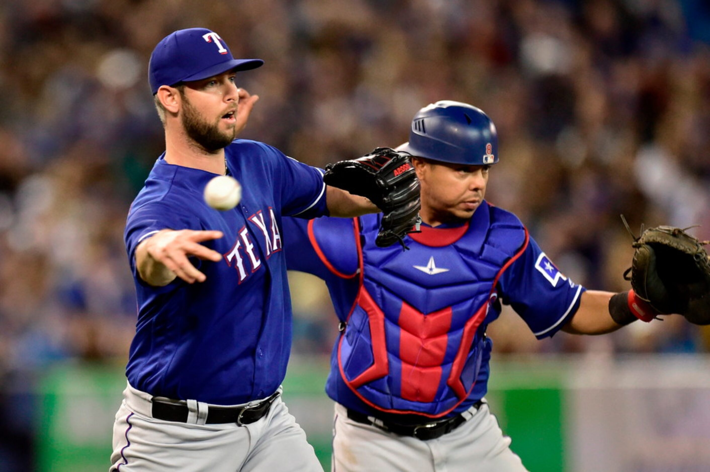 Texas Rangers relief pitcher Chris Martin throws to first to get the out on Toronto Blue...