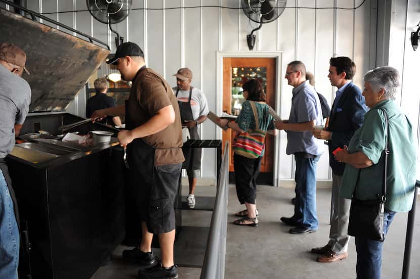 Guests form a line to order meats from the smoker at Ten 50 BBQ in Richardson.