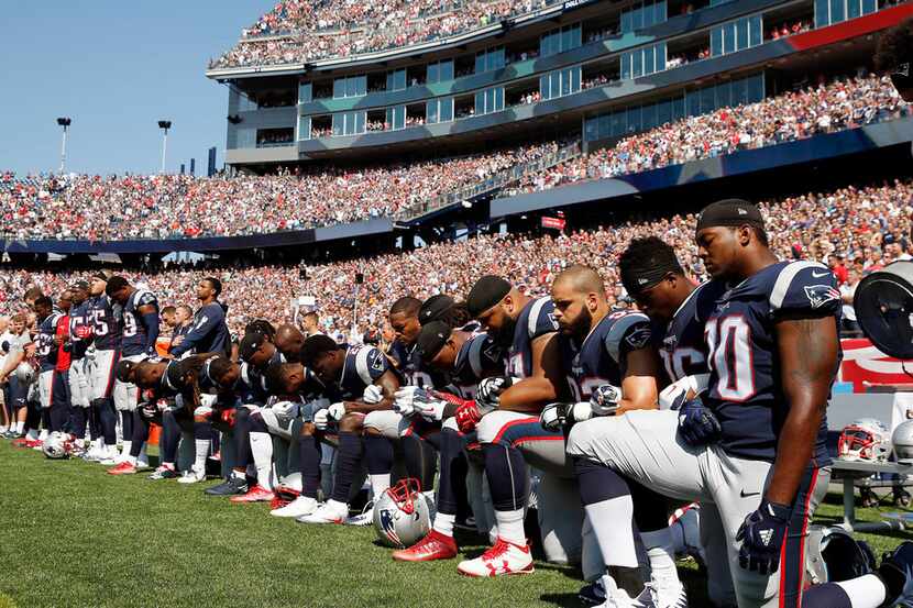 n this Sept. 24, 2017 file photo, several New England Patriots players kneel during the...