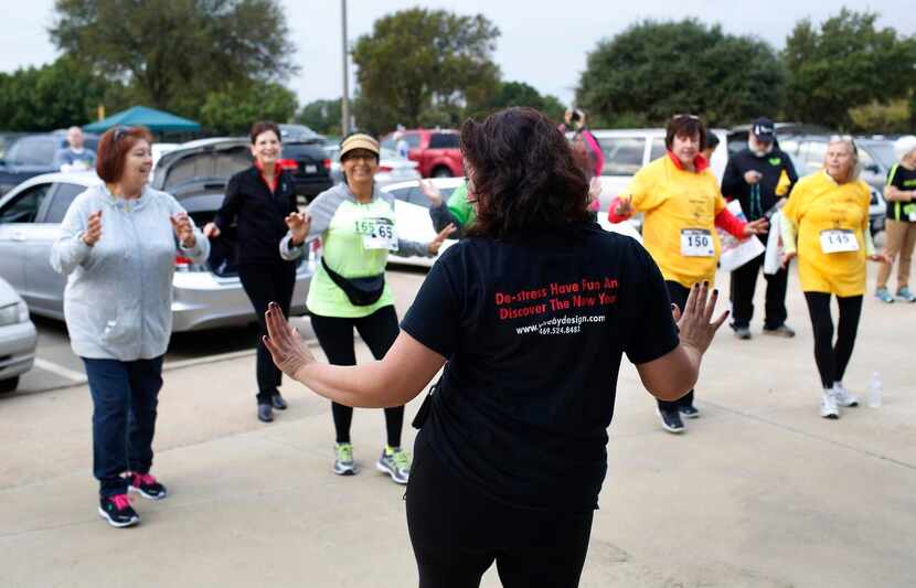 Left:  Kennya Sanchez helps race participants loosen up with some salsa music before the 5K...