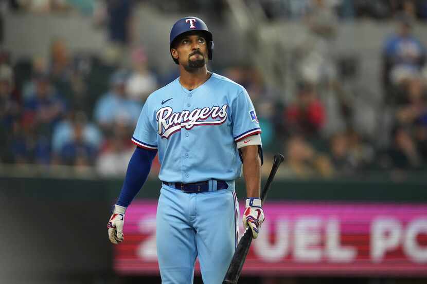 Texas Rangers' Marcus Semien walks to the dugout after striking out during the seventh...