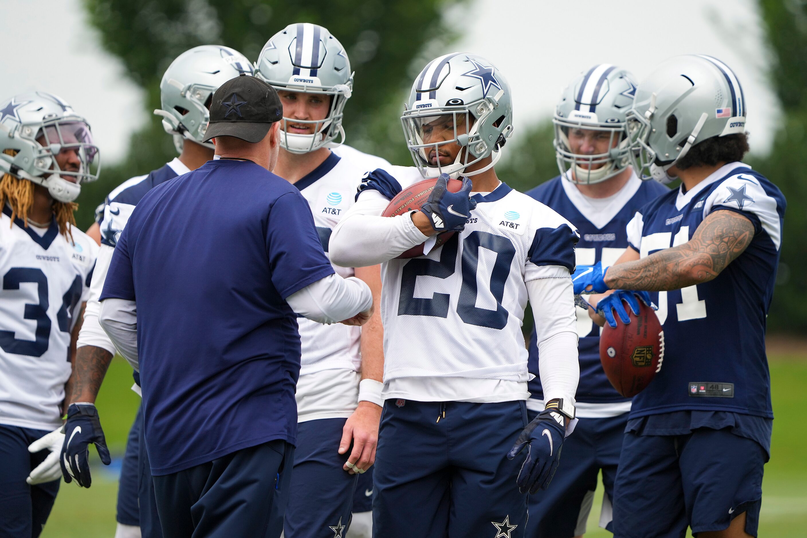 Dallas Cowboys running back Tony Pollard (20) clutches the ball while participating in a...