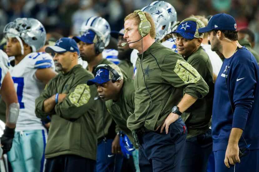Dallas Cowboys head coach Jason Garrett and quarterback Tony Romo (right) watch from the...