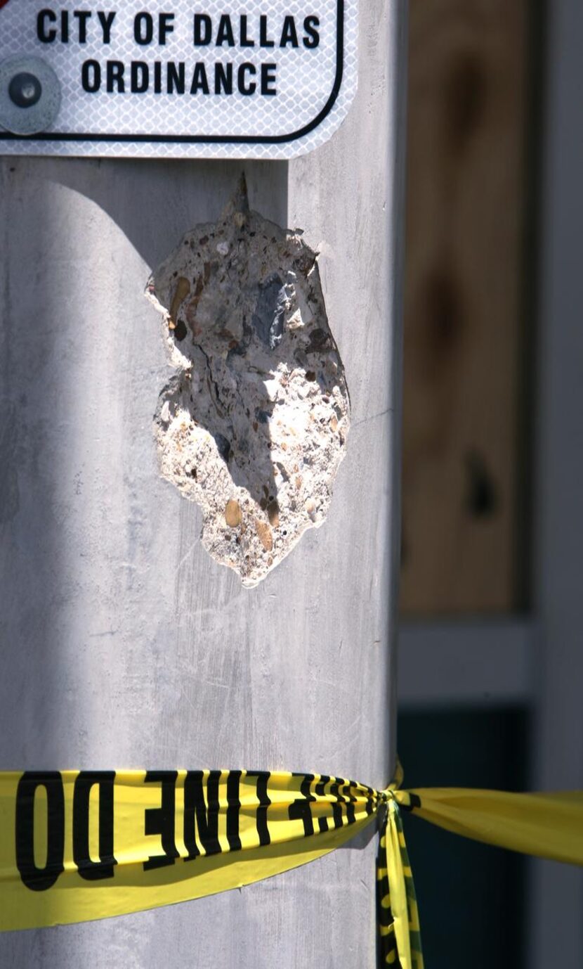 
A large chip in the police headquarters building made by gunfire was marked by tape Sunday.
